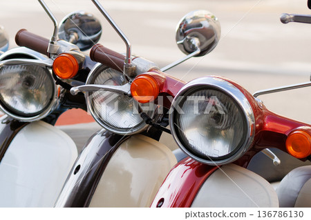 Vintage scooters lined up on a city street showcasing colorful designs and classic features Vintage scooters lined up on a city street showcasing colorful designs and classic features 136786130