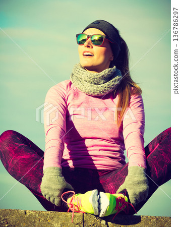 Woman resting after doing sports outdoors on cold day 136786297