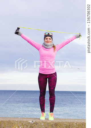 Woman training outdoor with jump rope on cold day 136786302