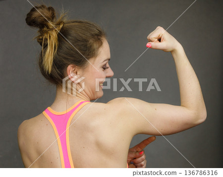 Woman showing muscles of the back and shoulders Woman showing muscles of the back and shoulders 136786316