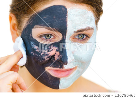 Girl remove black white mud mask from face Girl remove black white mud mask from face 136786465