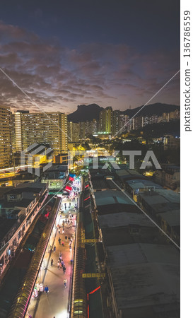 Night market walkway glowing beneath towering city skyline Feb 5 2026 136786559