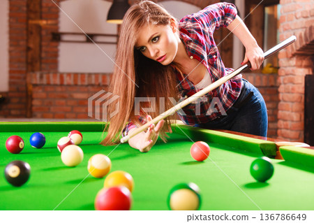 Young woman playing billiard. Young woman playing billiard. 136786649