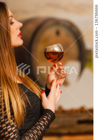 Woman tasting wine in rural cottage interior Woman tasting wine in rural cottage interior 136786666