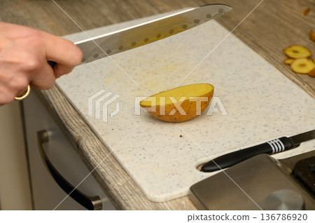 Preparing Rustic Potato Wedges on White Board Preparing Rustic Potato Wedges on White Board 136786920