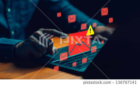 Cybersecurity concept showing a person receiving phishing or spam email alerts on a laptop. Symbolizing data breach, email security risk, online scam detection, and protection against cyber threats. 136787141