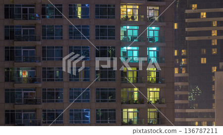 Windows of the multi-storey building of glass and steel lighting inside and moving people within timelapse Windows of the multi-storey building of glass and steel lighting inside and moving people within timelapse 136787211