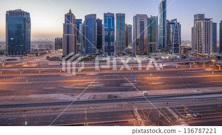 Aerial view of Jumeirah lakes towers skyscrapers night to day timelapse with traffic on sheikh zayed road. Aerial view of Jumeirah lakes towers skyscrapers night to day timelapse with traffic on sheikh zayed road. 136787221