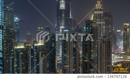 Aerial cityscape timelapse at night with illuminated modern architecture in Downtown of Dubai, United Arab Emirates. Aerial cityscape timelapse at night with illuminated modern architecture in Downtown of Dubai, United Arab Emirates. 136787226