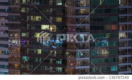Windows of the multi-storey building of glass and steel lighting inside and moving people within timelapse Windows of the multi-storey building of glass and steel lighting inside and moving people within timelapse 136787240