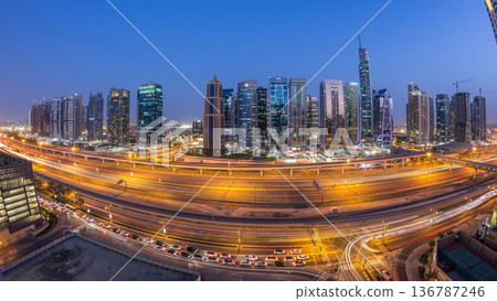 Aerial view of Jumeirah lakes towers skyscrapers day to night timelapse with traffic on sheikh zayed road. Aerial view of Jumeirah lakes towers skyscrapers day to night timelapse with traffic on sheikh zayed road. 136787246