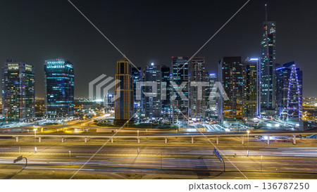 Aerial view of Jumeirah lakes towers skyscrapers night timelapse with traffic on sheikh zayed road. Aerial view of Jumeirah lakes towers skyscrapers night timelapse with traffic on sheikh zayed road. 136787250