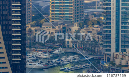 Promenade and canal in Dubai Marina with luxury skyscrapers and yachts around timelapse, United Arab Emirates 136787369