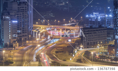 Aerial view of a road intersection in a big city night timelapse. Aerial view of a road intersection in a big city night timelapse. 136787398