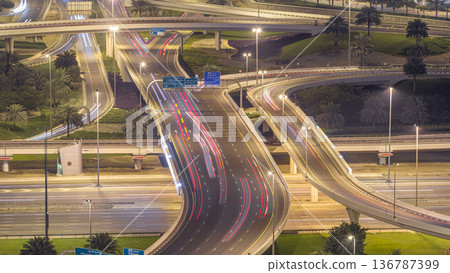 Aerial view of a road intersection in a big city night timelapse. Aerial view of a road intersection in a big city night timelapse. 136787399