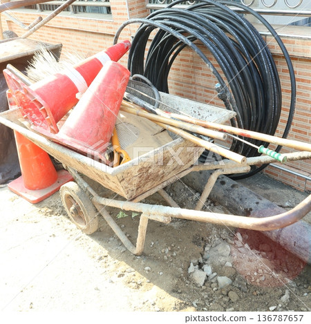 Construction Site Equipment Set - Industrial Water Pipes, Wheelbarrow, and Traffic Cones 136787657