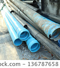 Stack of Blue PVC and Black HDPE Industrial Water Pipes on Construction Site 136787658
