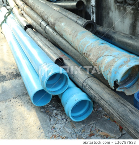 Stack of Blue PVC and Black HDPE Industrial Water Pipes on Construction Site Stack of Blue PVC and Black HDPE Industrial Water Pipes on Construction Site 136787658