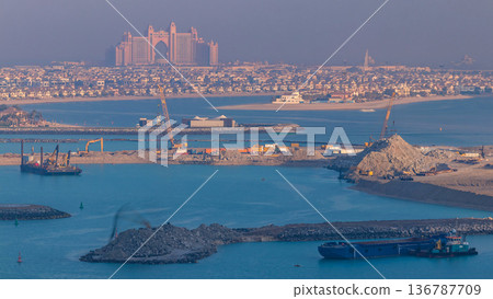 A breathtaking aerial view of the Palm Jumeirah during sunrise timelapse from a rooftop, Dubai, United Arab Emirates A breathtaking aerial view of the Palm Jumeirah during sunrise timelapse from a rooftop, Dubai, United Arab Emirates 136787709