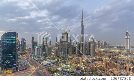 Dubai Downtown day to night timelapse. Aerial view over big futuristic city by night. Dubai Downtown day to night timelapse. Aerial view over big futuristic city by night. 136787898