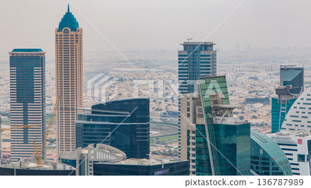 Dubai's business bay towers before sunset timelapse. Rooftop view of some skyscrapers and new towers under construction. Dubai's business bay towers before sunset timelapse. Rooftop view of some skyscrapers and new towers under construction. 136787989