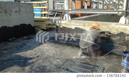 Roofer installing roofing felt with heating and melting of bitumen roll by torch on flame during roof repair timelapse Roofer installing roofing felt with heating and melting of bitumen roll by torch on flame during roof repair timelapse 136788142