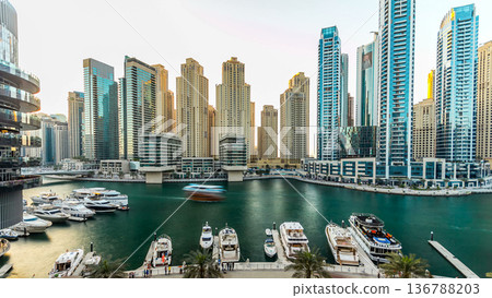 Dubai marina with modern buildings and traditional boat timelapse Dubai marina with modern buildings and traditional boat timelapse 136788203