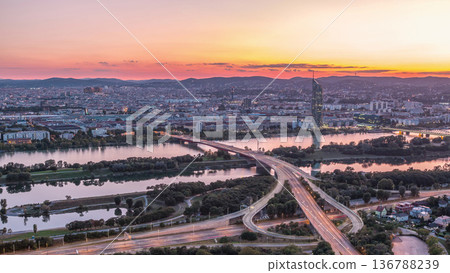 Aerial panoramic view over Vienna city with skyscrapers, historic buildings and a riverside promenade day to night timelapse in Austria. 136788239