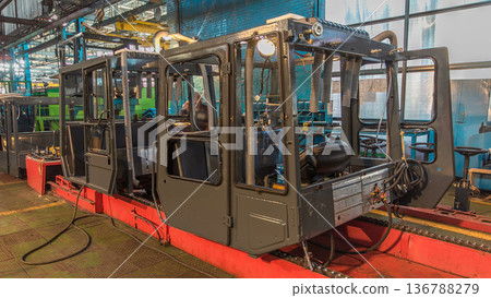 Conveyor assembly stage the body of tractor at big industrial factory timelapse Conveyor assembly stage the body of tractor at big industrial factory timelapse 136788279