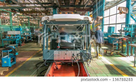 Conveyor assembly stage the body of tractor at big industrial factory timelapse Conveyor assembly stage the body of tractor at big industrial factory timelapse 136788283