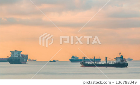 Early morning scene of cargo ships and tankers anchored off of Singapore's coast timelapse 136788349