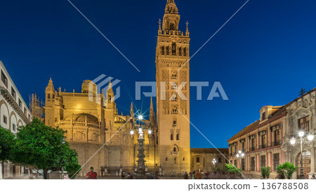 La Giralda and Seville Cathedral day to night timelapse glowing under the night sky. 136788508
