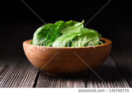 Baby spinach leaves in handmade wooden bowl Baby spinach leaves in handmade wooden bowl 136788770