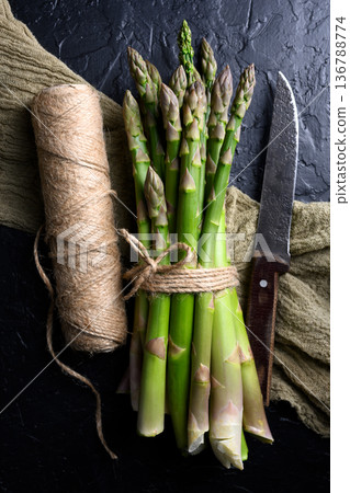 Bundled green asparagus tied with twine and knife 136788774