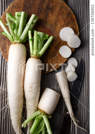 Fresh daikon radish with sliced pieces on rustic woo Fresh daikon radish with sliced pieces on rustic woo 136788802