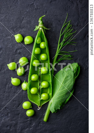 Fresh green peas scattered on dark background 136788813