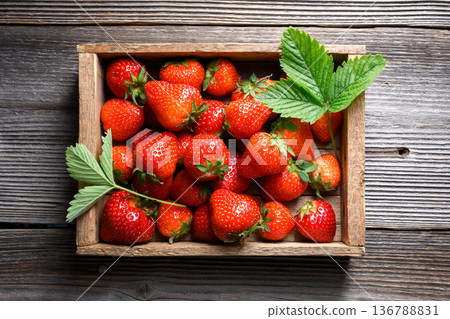 Freshly harvested ripe red strawberries in a small wooden crate Freshly harvested ripe red strawberries in a small wooden crate 136788831