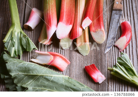 Rhubarb stems and sliced pieces arranged on wooden background Rhubarb stems and sliced pieces arranged on wooden background 136788866