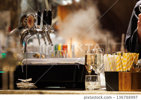 Bubbly drinks and steaming dishes at a modern bar captured during a lively evening 136788997