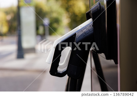 Charging station for electric vehicles nestled in a serene urban setting on a bright sunny day Charging station for electric vehicles nestled in a serene urban setting on a bright sunny day 136789042