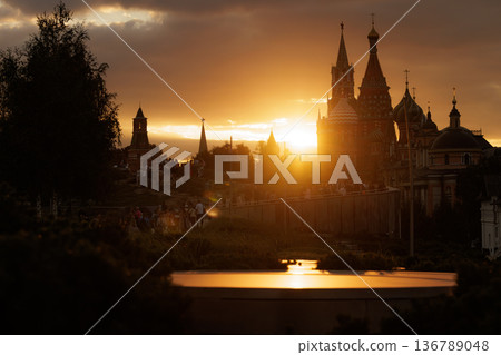 Sunset over historic buildings with silhouettes of spires in a park setting 136789048