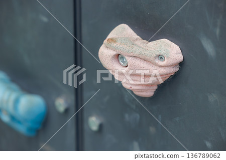 Colorful climbing holds on an indoor rock climbing wall for sport and recreation Colorful climbing holds on an indoor rock climbing wall for sport and recreation 136789062