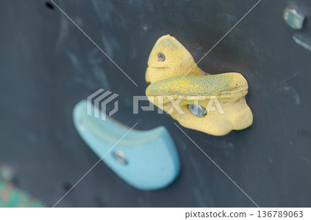 Colorful climbing holds mounted on a wall at an indoor rock climbing gym for training and recreation Colorful climbing holds mounted on a wall at an indoor rock climbing gym for training and recreation 136789063