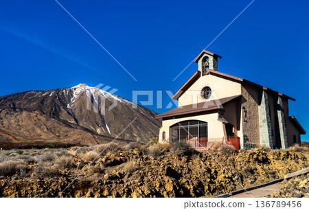 Scenic view of Ermita de las Nieves chapel and snow-capped Mount Teide in Teide National Park, Tenerife, Canary Islands, Spain. Features a stone church in a rocky volcanic landscape. Scenic view of Ermita de las Nieves chapel and snow-capped Mount Teide in Teide National Park, Tenerife, Canary Islands, Spain. Features a stone church in a rocky volcanic landscape. 136789456