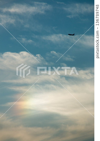 A passenger plane flying against the backdrop of a clear blue sky and soft light A passenger plane flying against the backdrop of a clear blue sky and soft light 136789748