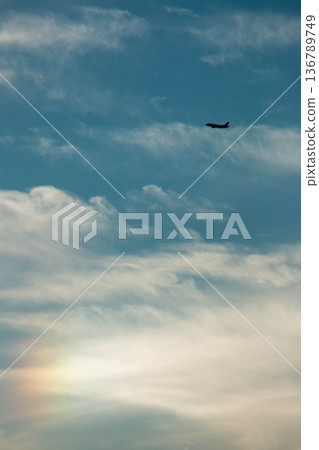 A passenger plane flying against the backdrop of a clear blue sky and soft light A passenger plane flying against the backdrop of a clear blue sky and soft light 136789749