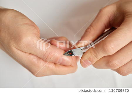 Person removing excess skin from fingertips for neat and healthy nails Person removing excess skin from fingertips for neat and healthy nails 136789870