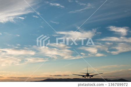 一架客機在藍天下降落在跑道上 136789972