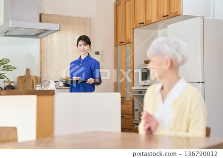 A caregiver providing meal support during a home care visit A caregiver providing meal support during a home care visit 136790012