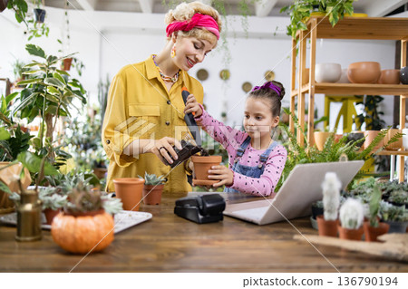 A young girl and her mother enjoy a fun afternoon of gardening, learning about plants and nature A young girl and her mother enjoy a fun afternoon of gardening, learning about plants and nature 136790194